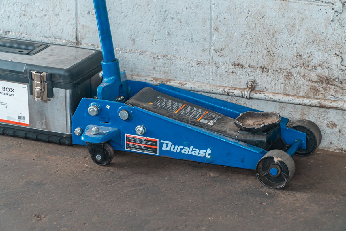 Blue floor jack and toolbox in an automotive garage
