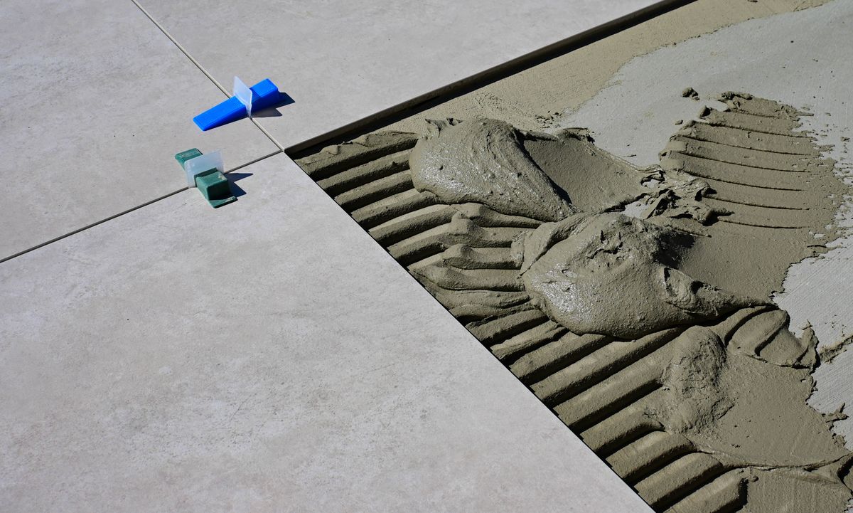 Wet cement and spacers during floor installation
