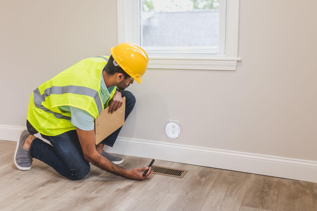 Worker in a hard hat inspecting a floor